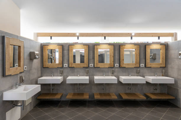 istock Public bathroom with five sinks, mirrors and soap dispensers. Modern and simple. 1805717356