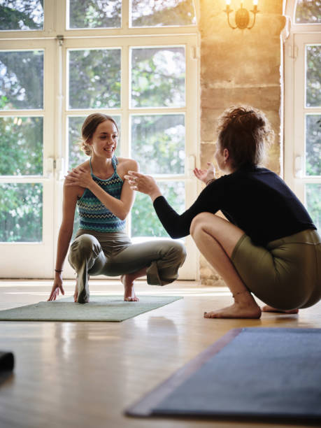 istock Talking, instructor or women in yoga class for support, conversation or body flexibility in studio together. Coach, teaching or calm people learning in pilates for chakra, energy or wellness to relax 1805721171