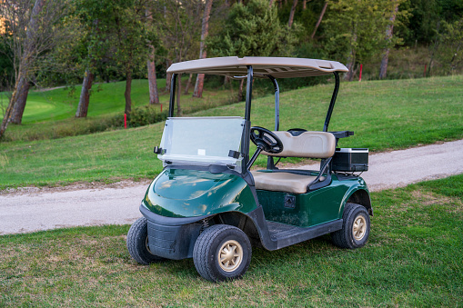 Golf cart on the course at sunset. No people and room for copy space.