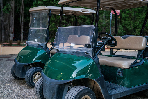 Two golf carts parked at the golf facility. No people.