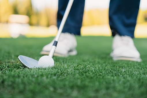 Detail of a golfer just before the swing. Focus on the golf club and ball.