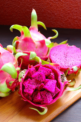 Delectable Diced Ripe Red Flesh Dragon Fruit or Pink Pitaya with Whole Fruits in the Backdrop