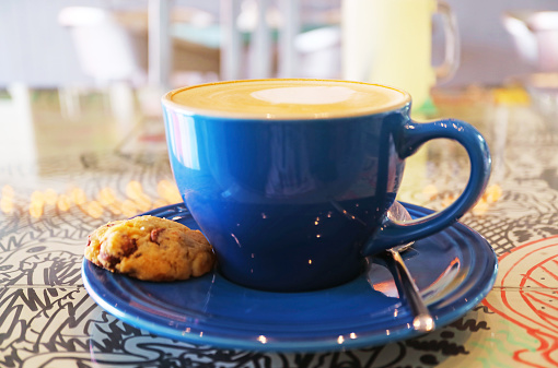 Cup of cappuccino coffee with a chocolate chip cookie isolated on the table