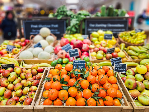 Fresh fruit, including clementines and apples on display and for sale at the delicatessen.