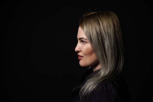 istock sad female silhouette on black background profile view, looking aside. 1805763198