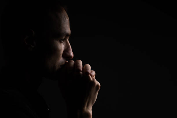 istock Portrait of a handsome man praying over gray background 1805777401