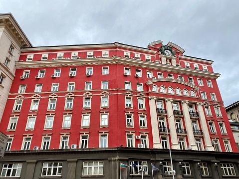 Close-up of red town hall with clock, paintings and ornaments in Basel, Switzerland