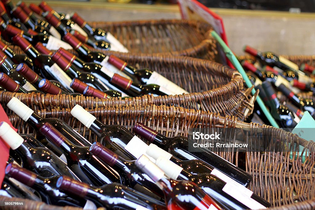 Botellas de vino en cestas - Foto de stock de Tienda de bebidas alcohólicas libre de derechos