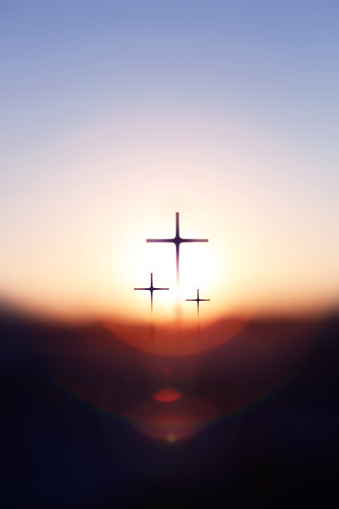 Shining new year sunrise background with bright rising sun bokeh and holy cross silhouette of Jesus Christ