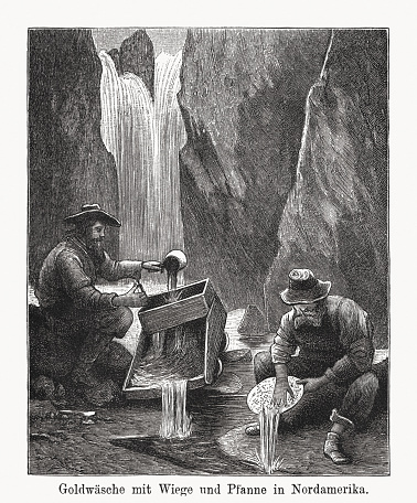 Gold prospecting with cradle and pan in North America. Nostalgic scene from the past. Wood engraving, published in 1894.