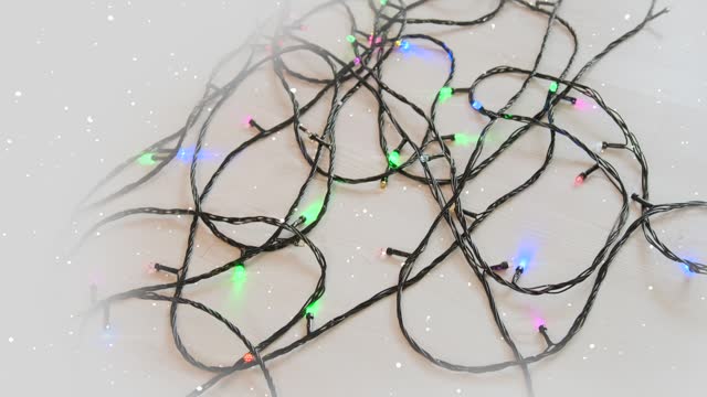 LED thread glowing with multi-colored lights garlands lies on floor ready to decorate New Year tree