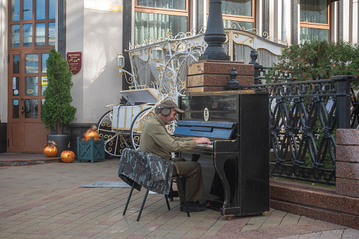 Minsk, Belarus. October 15, 2023 A pianist performs melodies on a street piano near a restaurant in the city center