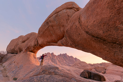 Young couple in Spitzkoppe area with picturesque stone arches and unique rock formations in Damaraland Namibia