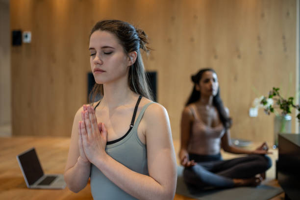 istock Two young women are learning yoga at home 1805842659