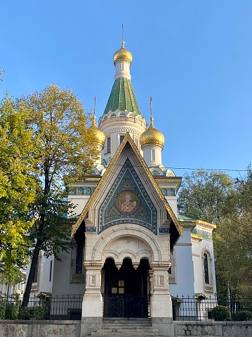 Sumy, Ukraine - April 1, 2019: Blue dome with a gold cross shining in the sun of Prophet-Ilyinsky temple in Sumy. Beautiful orthodox background with copy space, part of the church in classicism style