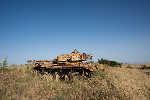 Rusted, abandoned tank from the Yom Kippur war in a meadow on the Golan Heights in northern Israel.