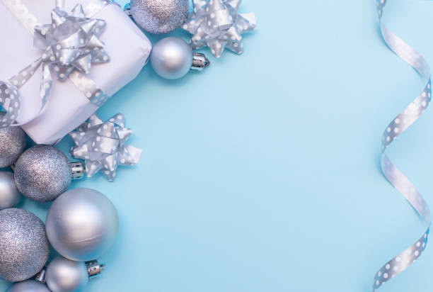 istock Christmas composition white present box with christmas silver tree toys at the blue background. 1805858787