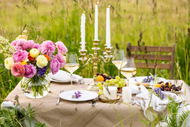 夏の夕暮れ、牧草地でのロマンチックなデート、プロポーズ。フィールドでのロマンチックなサンセットディナー。豪華な料理、レストランでのシャンパンドリンクのグラスと2人用のテーブ - wedding champagne table wedding reception ストックフォトと画像