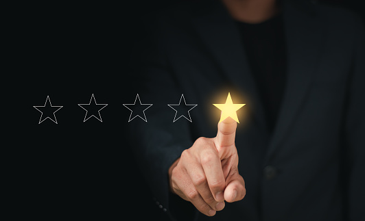Customers rate service of Businessmen choose to rate 5 stars using smart phone and give five star symbol. Excellent rating. User give rating, feedback, good business network score.