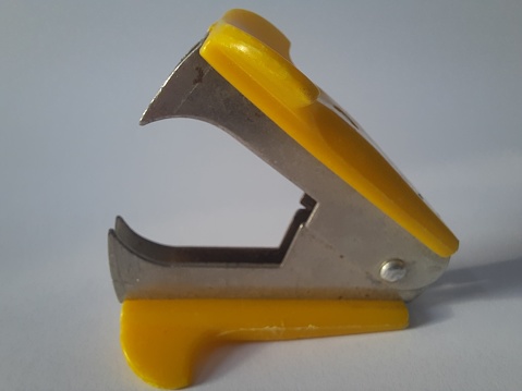 Yellow staple extractor/ remover on white background