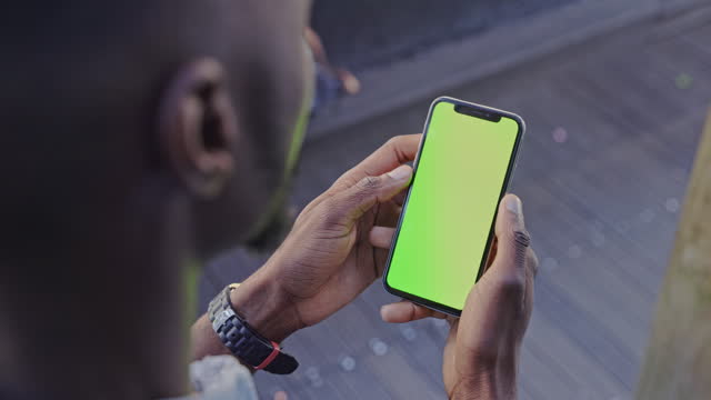 Closeup, hand and phone with green screen for mockup of social media, internet or website. Black person, male entrepreneur and mobile app with homepage for about us, faq or contact us by cellular