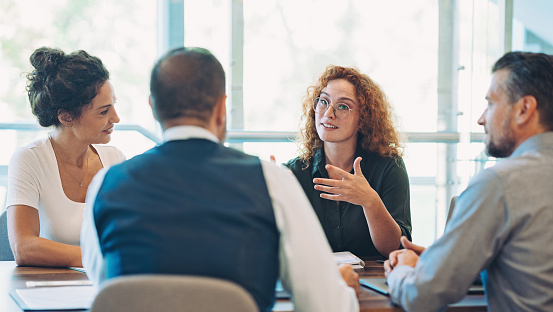 Business persons sitting around a table and talking