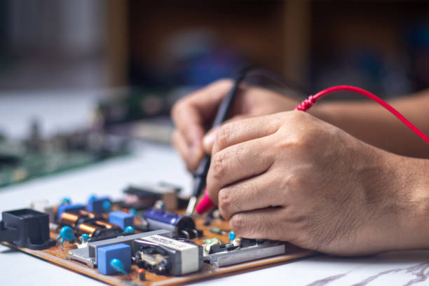 istock Technician using tool to measure circuit board, check and repair 1805898779