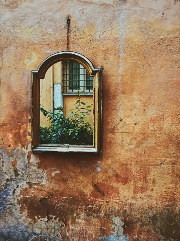Mirror on an orange traditional Roman wall