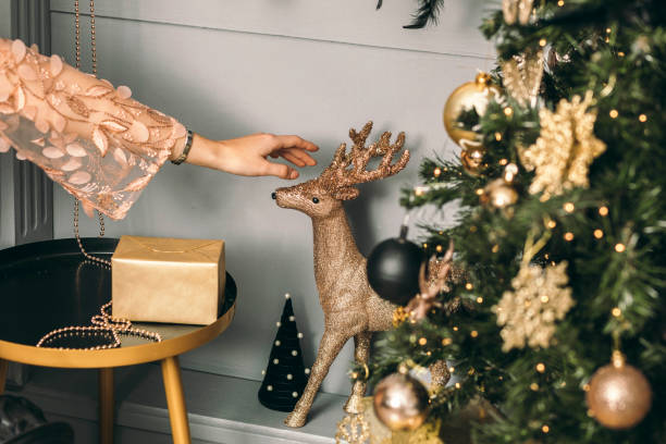Holiday Glamour: A Touch of Grace in Pink, Reaching for the Golden Deer stock photo