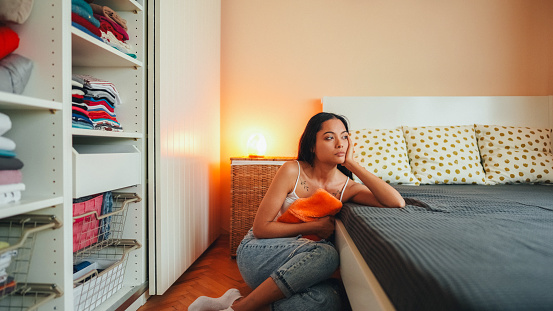 Woman with painful menstruation resting in bed