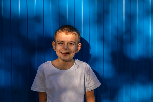 Dreams on the Horizon: A Boy's Hopeful Gaze Against the Blue Wall