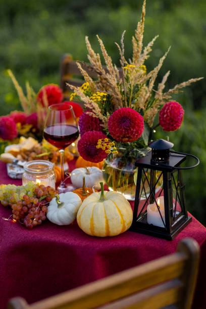 istock Fall mood, romantic date outdoors in the garden, candlelight dinner for a couple. Private wedding for two. Pumpkin countryside decor, red dahlia, cheese plate, grapes. Gourmet food, elegant setting 1805957882