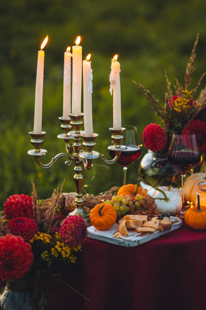 istock Fall mood, romantic date outdoors in the garden, candlelight dinner for a couple. Private wedding for two. Pumpkin countryside decor, red dahlia, cheese plate, grapes. Gourmet food, elegant setting 1805959023