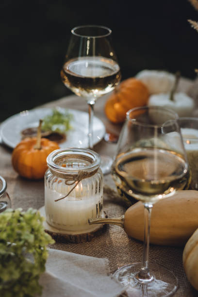 istock Fall table decoration with pumpkins, wine. Family thanksgiving dinner arrangement outdoors in the garden. Countryside style, simple handmade setting, autumn mood 1805964192