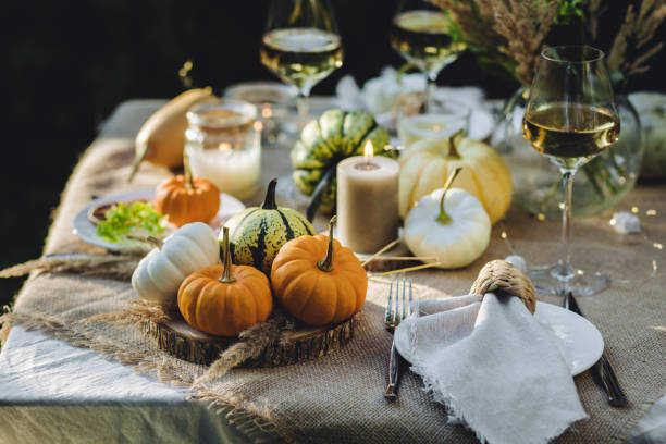 istock Fall table decoration with pumpkins, wine. Family thanksgiving dinner arrangement outdoors in the garden. Countryside style, simple handmade setting, autumn mood 1805964199