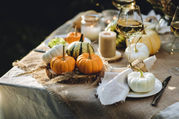 istock Fall table decoration with pumpkins, wine. Family thanksgiving dinner arrangement outdoors in the garden. Countryside style, simple handmade setting, autumn mood 1805964203