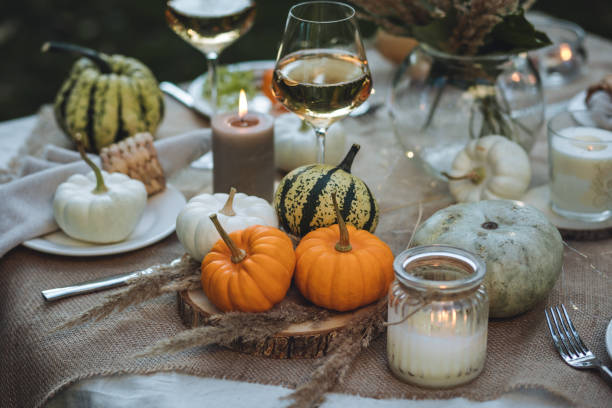 istock Fall table decoration with pumpkins, wine. Family thanksgiving dinner arrangement outdoors in the garden. Countryside style, simple handmade setting, autumn mood 1805964770