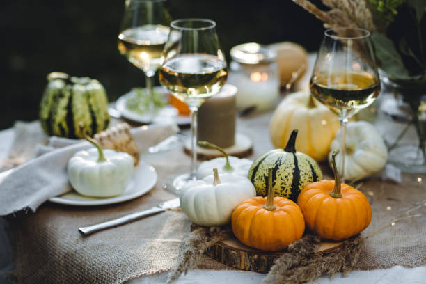 istock Fall table decoration with pumpkins, wine. Family thanksgiving dinner arrangement outdoors in the garden. Countryside style, simple handmade setting, autumn mood 1805964771