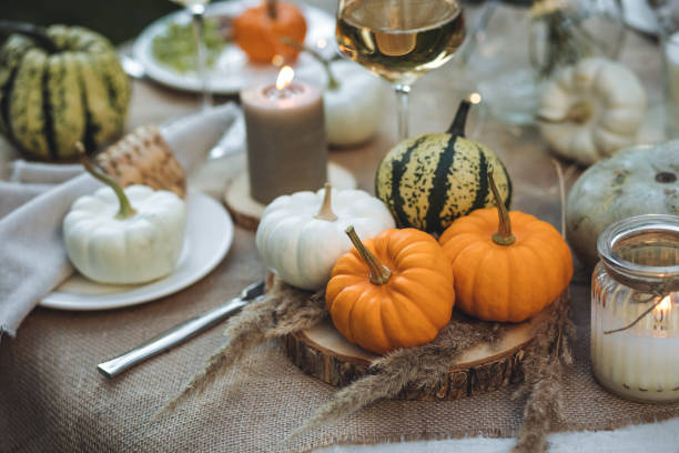 istock Fall table decoration with pumpkins, wine. Family thanksgiving dinner arrangement outdoors in the garden. Countryside style, simple handmade setting, autumn mood 1805964792