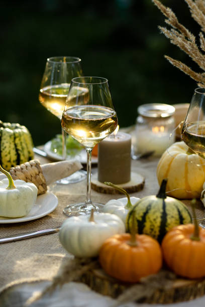 istock Fall table decoration with pumpkins, wine. Family thanksgiving dinner arrangement outdoors in the garden. Countryside style, simple handmade setting, autumn mood 1805964800