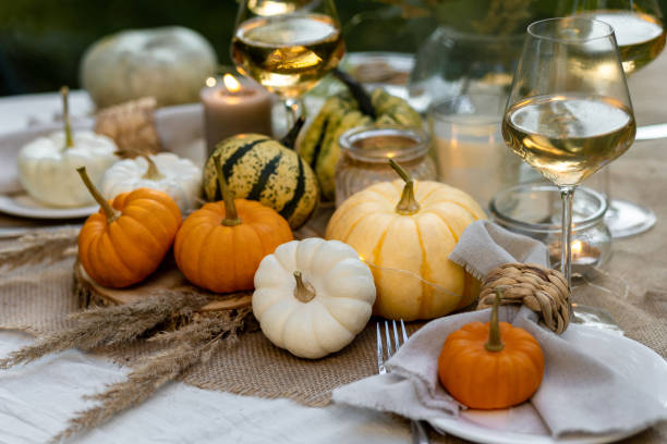 istock Fall table decoration with pumpkins, wine. Family thanksgiving dinner arrangement outdoors in the garden. Countryside style, simple handmade setting, autumn mood 1805967749
