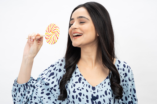 girl eating big colorful lollipop