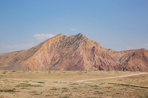 Red rocks with outcrops of geological ferro-magnetic rocks and other minerals in the mountains of Armenia.