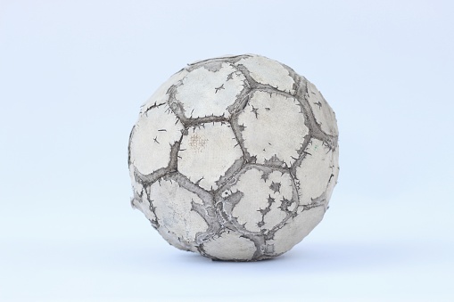 Detail of an old white soccer ball (Football) isolated on white background with green grass