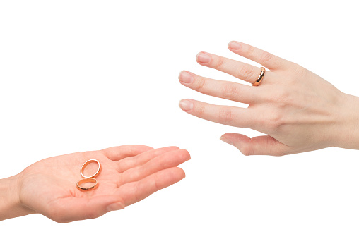 Two golden rings in a woman hand isolated on a white background. Wedding concept.