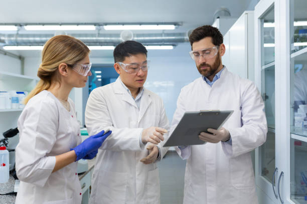 istock A team of three people, doctors, laboratory workers, scientists are standing inside a laboratory , researchers are communicating and discussing a scientific project, studying research material 1805990069