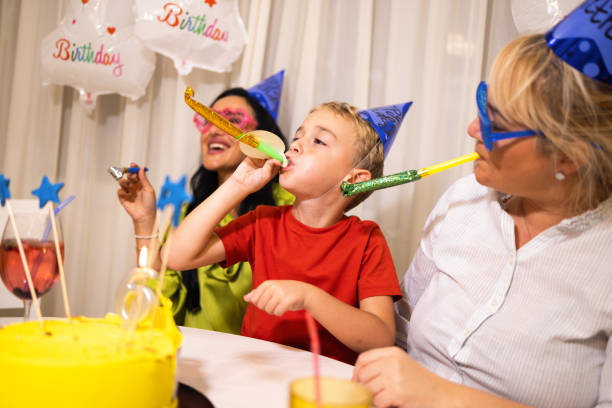 niño caucásico celebrando su 6º cumpleaños con su madre y su tía - ahijado fotografías e imágenes de stock