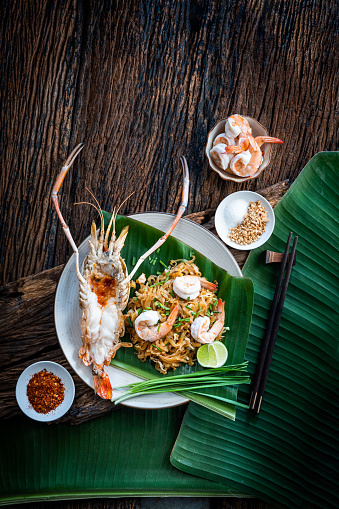 Pad Thai. Fried noodle Thai style with prawns. Pad Thai Goong Sod. Popular food in Thailand. delicious Thai food. Ancient food. food in a White bowl on a wooden table. Top view,