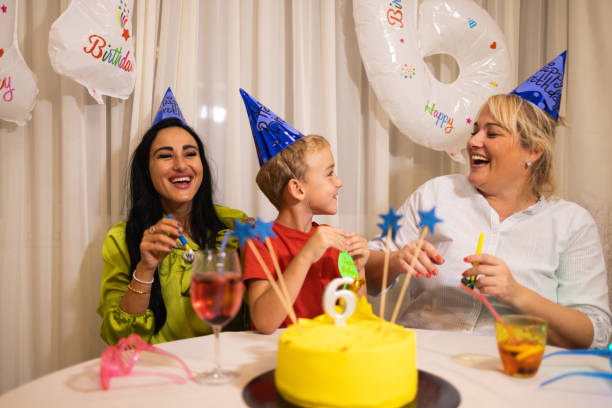 pareja de lesbianas caucásicas, celebrando el 6º cumpleaños de su hijo - ahijado fotografías e imágenes de stock