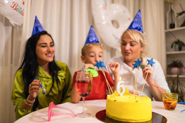 niño caucásico feliz celebrando su 6º cumpleaños con sus madres - ahijado fotografías e imágenes de stock